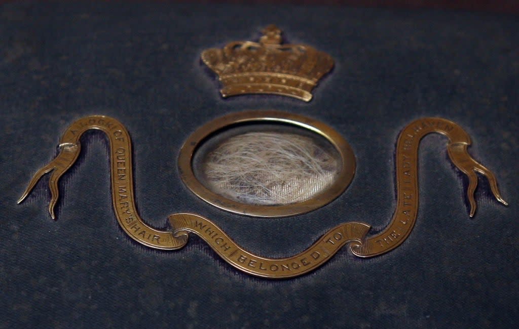 Circular display with hair, ornate crown design, and text: "Lock of Queen Mary's Hair Which Belonged to the Late Lady Churchill."