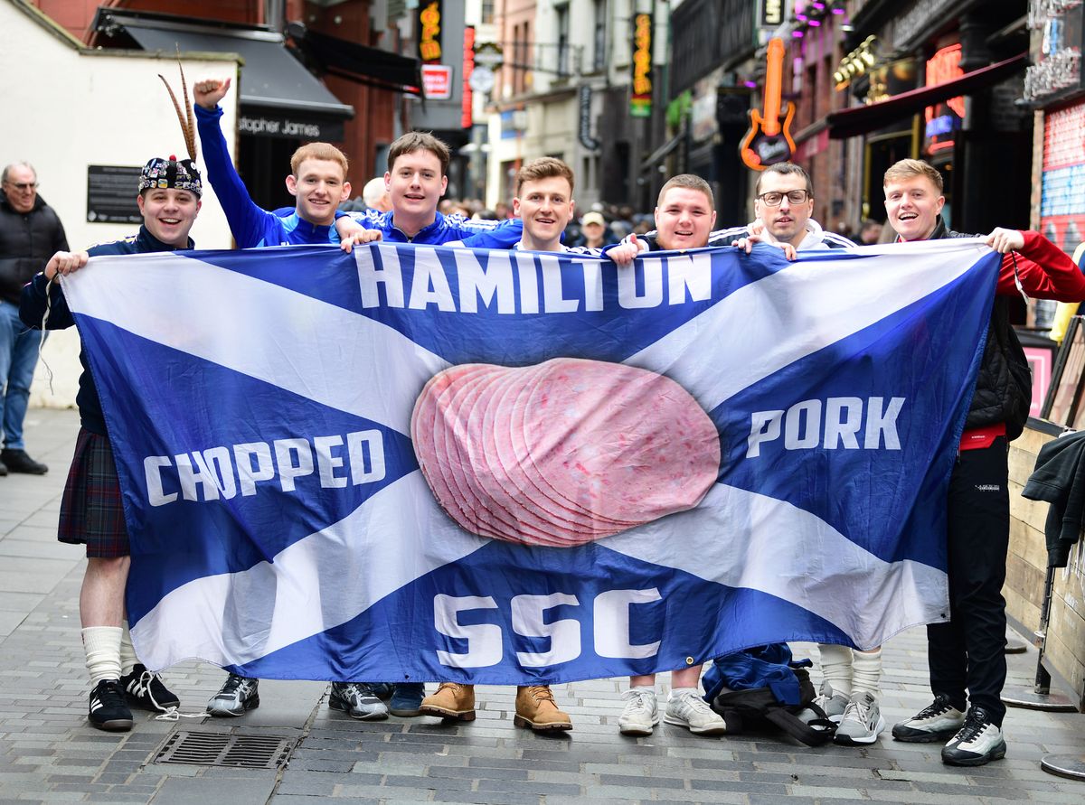 Scotland fans on Mathew Street, including Ben Mackie (second from left) and Niall Reagan (first from right) with the Hamilton chopped pork banner
