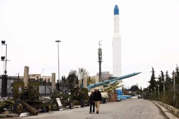 An Iranian couple walks near Iranian missiles in a park in Tehran, March 26, 2026.