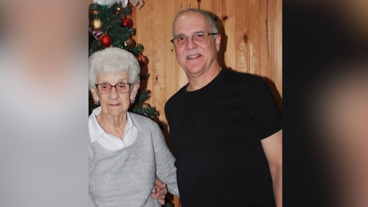 A man standing with an elderly woman.