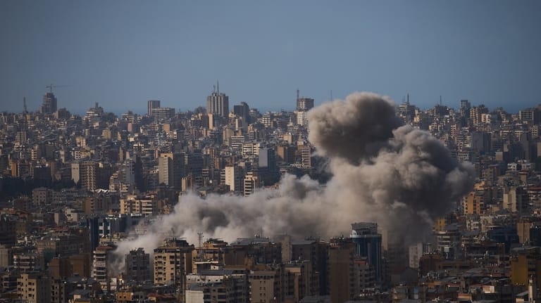 Smoke rises from Israeli airstrikes in Dahiyeh, a southern suburb...