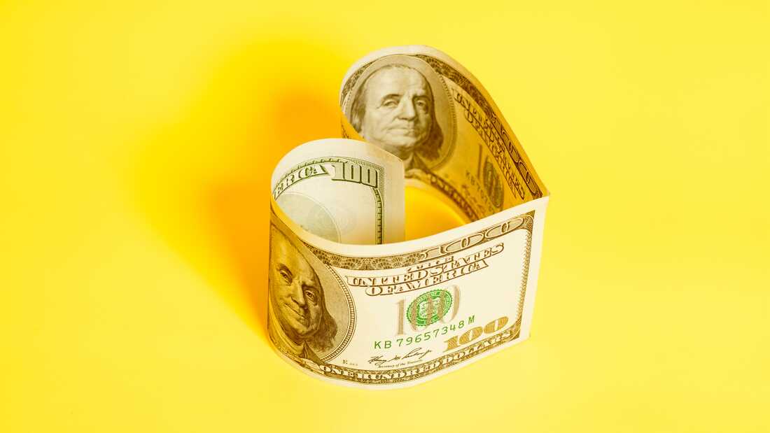 Hundred dollar bill in heart shape