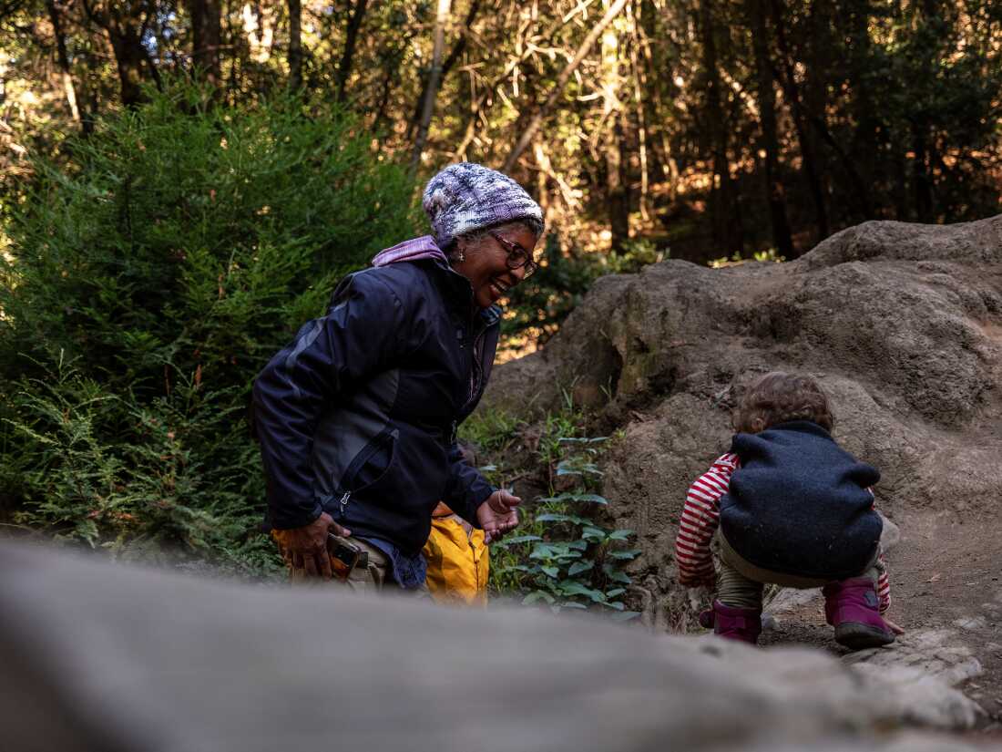 Rosa María Carranza encourages a toddler to navigate uneven ground at Joaquin Miller Park in Oakland, California, on Dec. 5, 2025. Carranza will lose Medicare when a federal policy restricting health care coverage for some lawfully present immigrants takes effect next year.