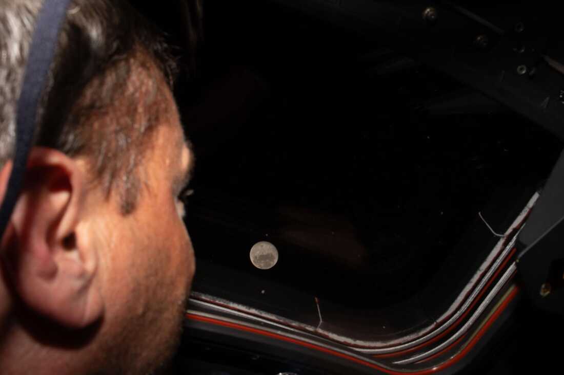 Astronaut Reid Wiseman looks out one of the Orion spacecraft's  windows at the moon ahead of the crew's lunar flyby. 