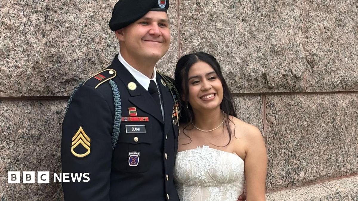 US Army Staff Sgt Matthew Blank wears his army uniform as he hugs his wife Annie Ramos in her white strapless wedding gown.