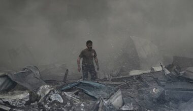 A first responder emerges through the smoke at the site of an Israeli airstrike that struck an apartment building in Beirut, Lebanon, Wednesday, April 8, 2026. (AP Photo/Bilal Hussein)