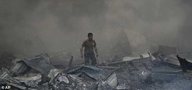 A first responder emerges through the smoke at the site of an Israeli airstrike that struck an apartment building in Beirut, Lebanon, Wednesday, April 8, 2026. (AP Photo/Bilal Hussein)