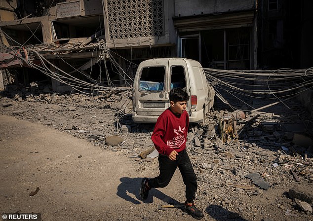 A boy runs past a damaged building at the site of an Israeli strike in Tyre, Lebanon, April 8, 2026. REUTERS/Adnan Abidi
