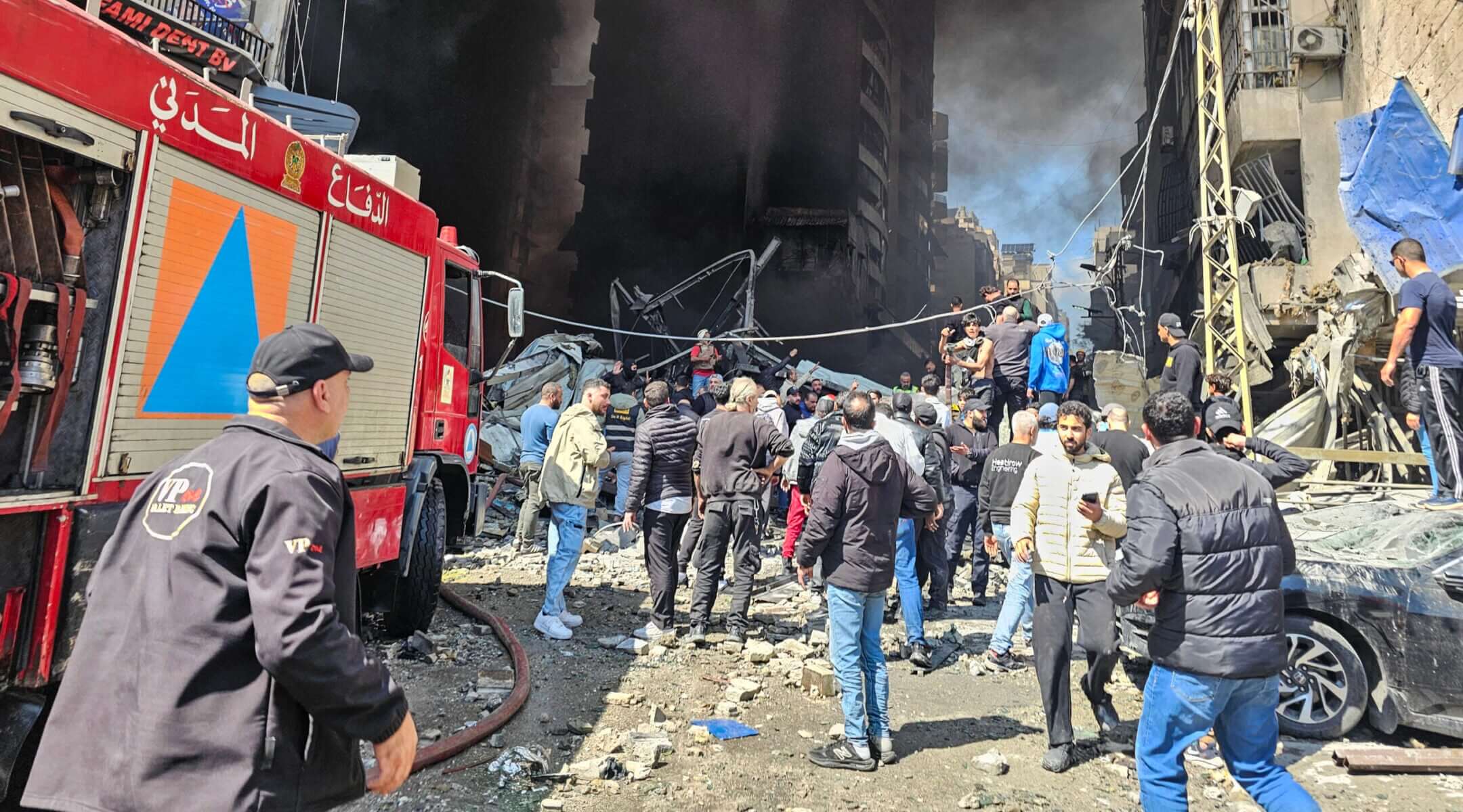 First responders and residents stand amid rubble at the site of an Israeli airstrike in Beirut’s Corniche al-Mazraa neighborhood on April 8, 2026. 