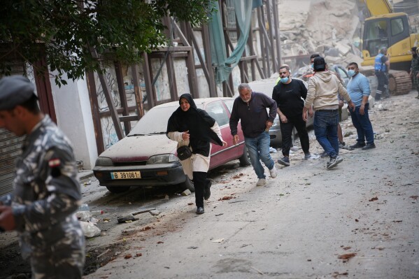 A group of people rushes out of the site of an Israeli airstrike in Beirut, Lebanon, Wednesday, April 8, 2026. (AP Photo/Emilio Morenatti)