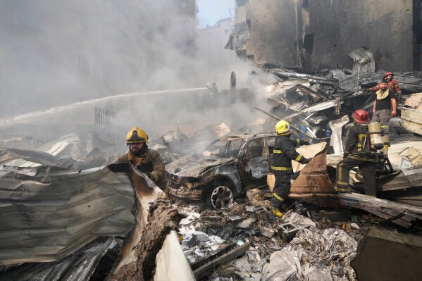 Firefighters gather at the site of an Israeli airstrike in Beirut, Lebanon, Wednesday, April 8, 2026. (AP Photo/Hussein Malla)