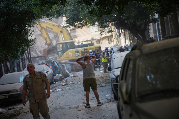 A man reacts as he watches an excavator remove debris at the site of an Israeli airstrike in Beirut, Lebanon, Wednesday, April 8, 2026. (AP Photo/Emilio Morenatti)