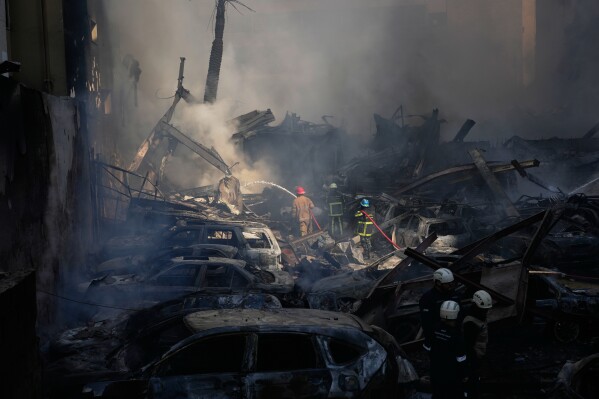 Firefighters spray smoldering debris at the site of an Israeli airstrike that struck a building in Beirut, Lebanon, Wednesday, April 8, 2026. (AP Photo/Hassan Ammar)