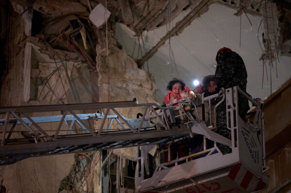A woman who survived an Israeli airstrike cries as she is rescued by a firefighter from a destroyed building in central Beirut, Lebanon, Wednesday, April 8, 2026. (AP Photo/Emilio Morenatti)