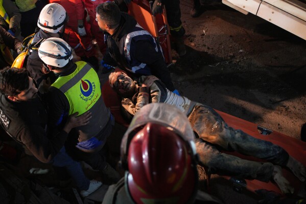 Rescuers carry an injured man from a destroyed building that was hit in an Israeli airstrike in central Beirut, Lebanon, Wednesday, April 8, 2026. (AP Photo/Emilio Morenatti)