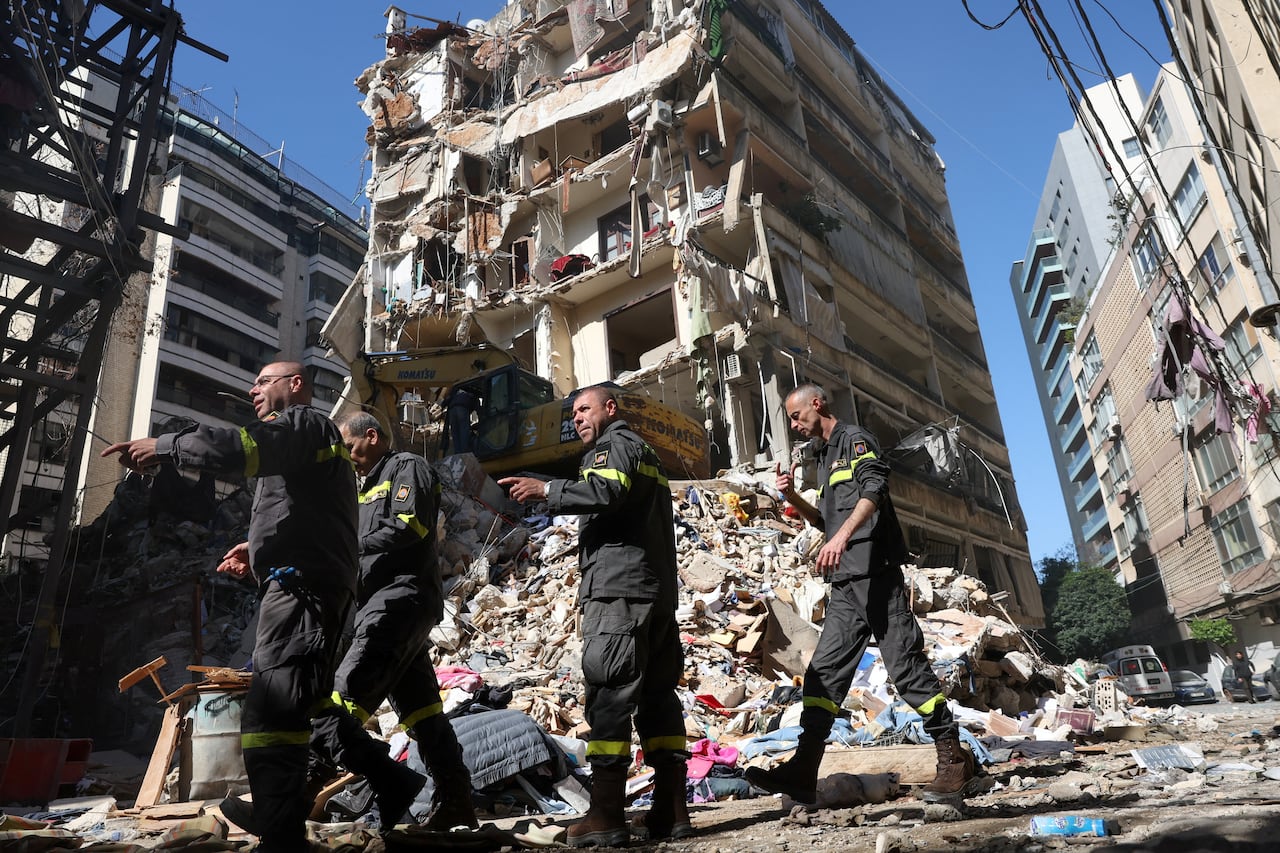 Rescuers  work at the scene of a destroyed building.