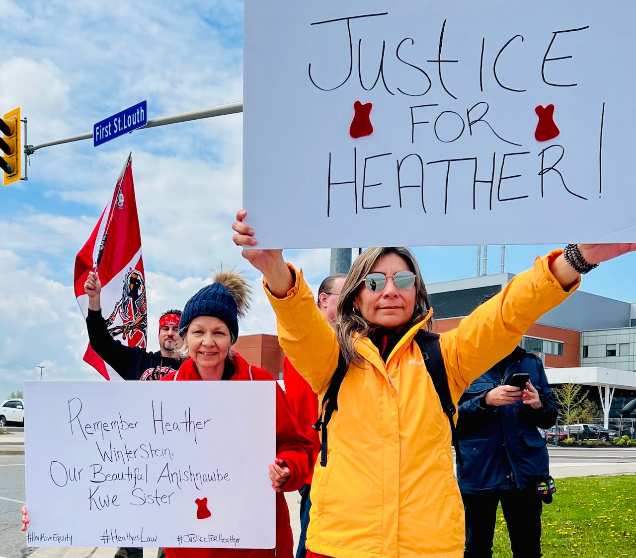 woman holds sign that says justice for heather
