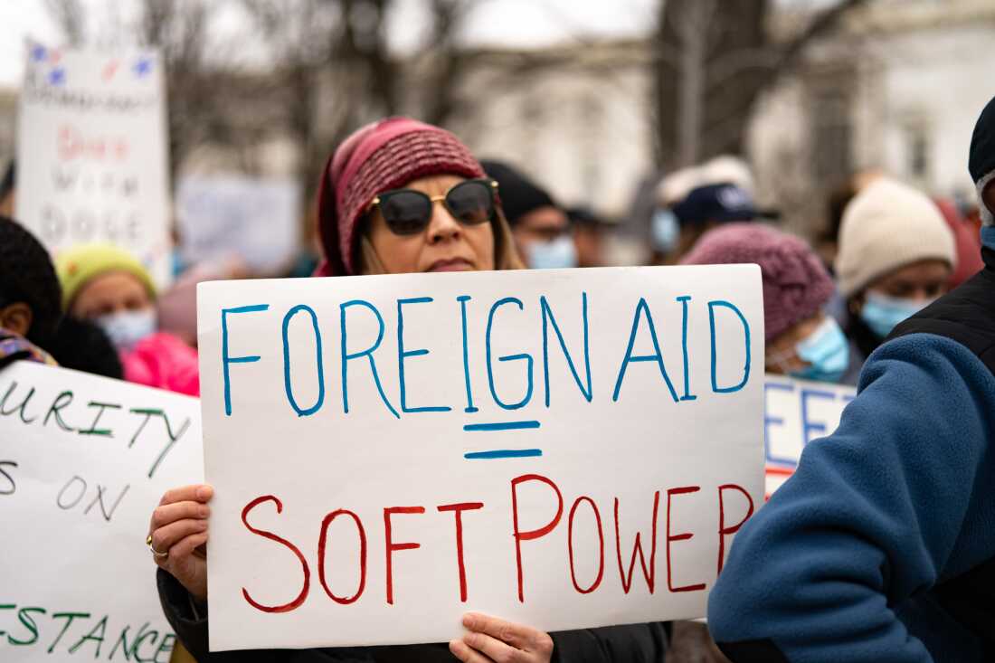 A protester carries a sign that equates foreign aid with soft power during a rally near the U.S. Capitol to protest the dismantling of USAID, the international agency charged with dispensing humanitarian aid around the world on behalf of the United States, February 5, 2025.