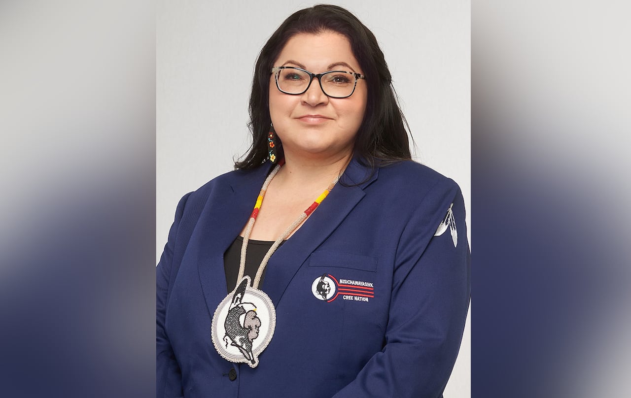 A woman with glasses and long black hair smiles