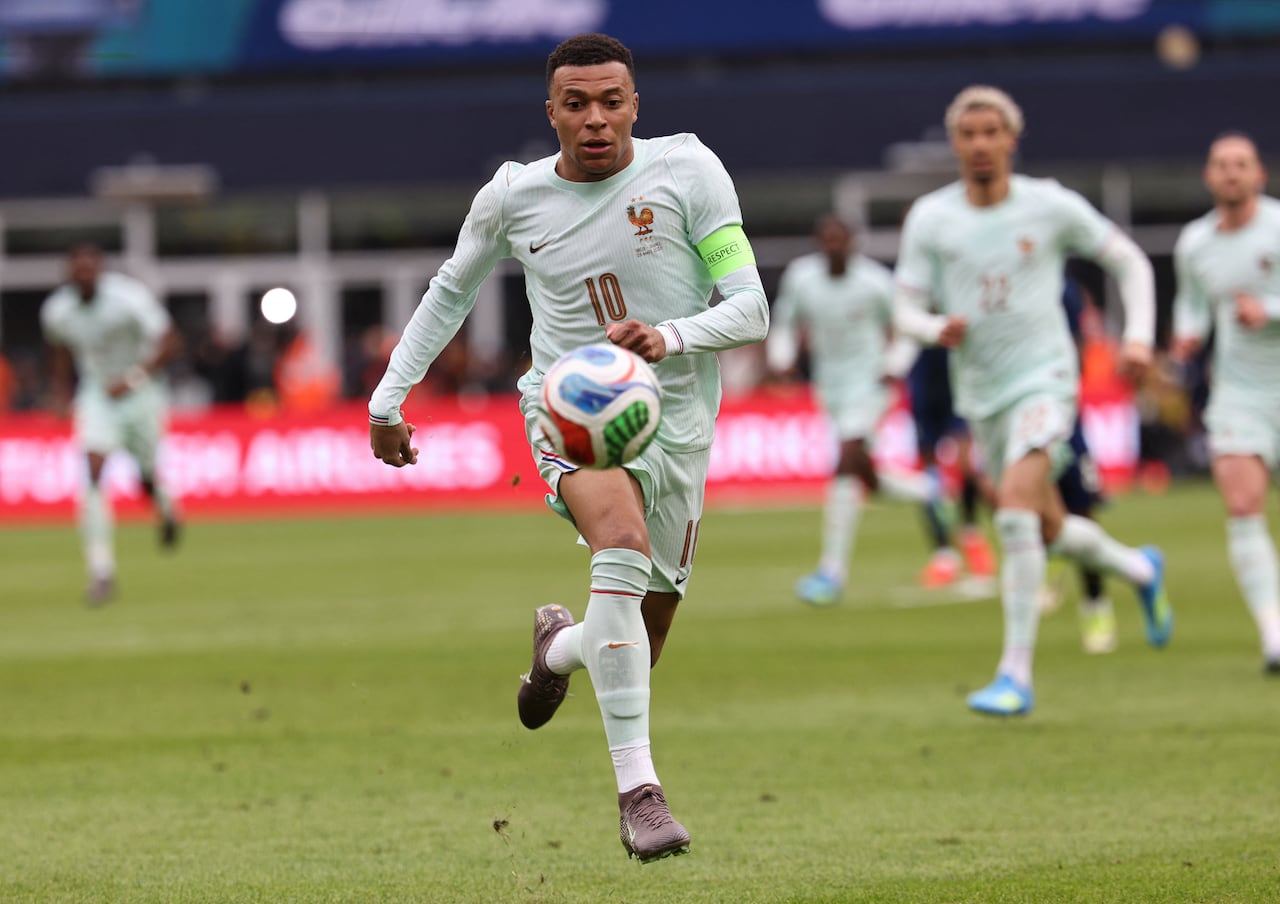 A player in a light green kit with ill-fitting shoulders, No. 10, chases the ball during a soccer match.