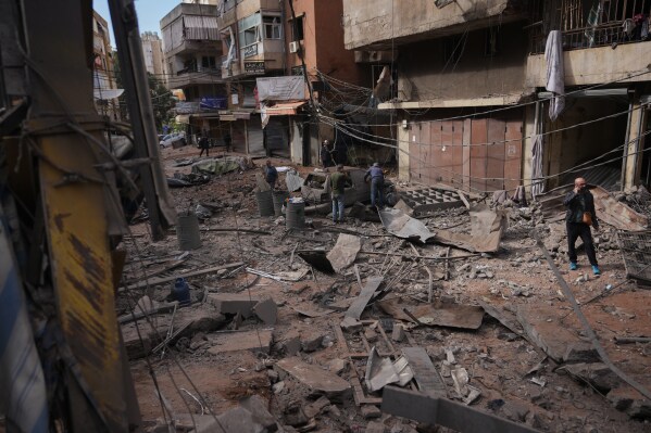 People inspect debris and damaged vehicles at the site of an Israeli airstrike in Dahiyeh, Beirut's southern suburbs, Lebanon, Thursday, April 9, 2026. (AP Photo/Hassan Ammar)