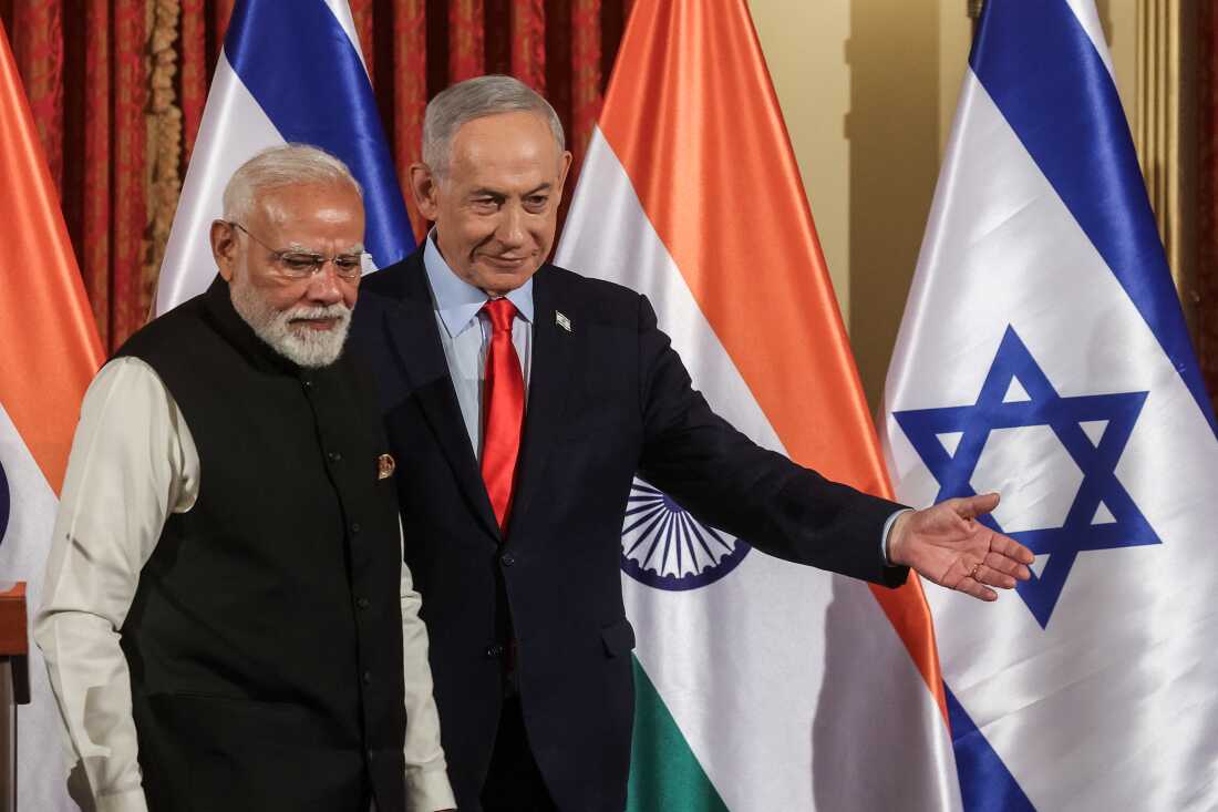 Israeli Prime Minister Benjamin Netanyahu and Indian Prime Minister Narendra Modi walk next to one another as they leave after a press conference in Jerusalem on February 26. Behind them are alternating Israeli and Indian flags.