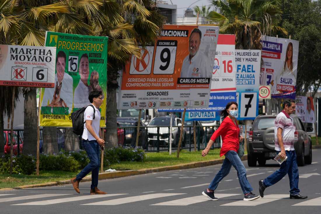 Pedestrians pass election campaign signs for presidential and congressional candidates, before the weekend's election in Lima, Peru, April 10, 2026.