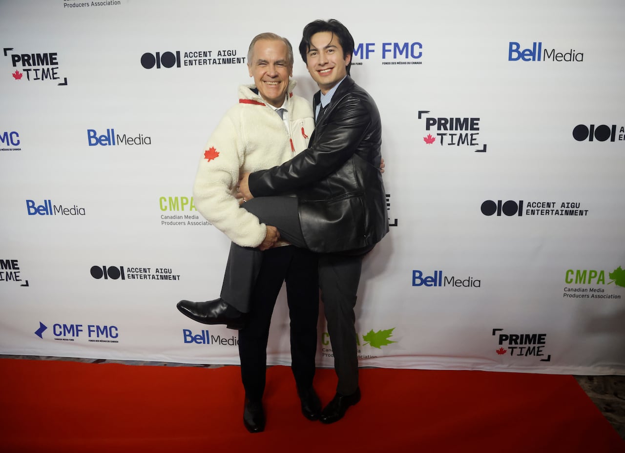 Prime Minister Mark Carney poses for a photo on the red carpet with Hudson Williams
