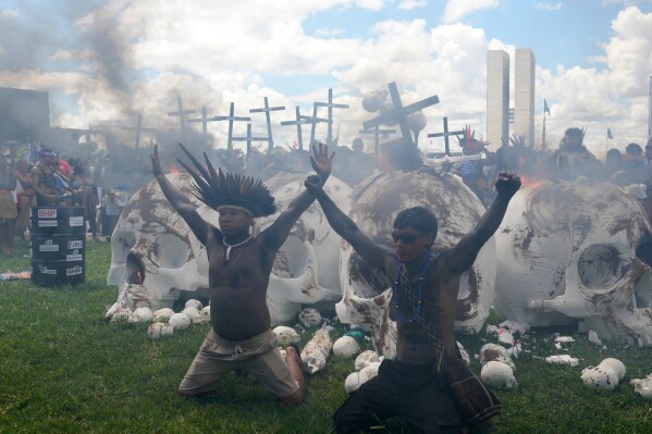 Indigenous protesters set fire to skull sculptures representing lawmakers to protest Congress during the annual "Acampamento Terra Livre," or Free Land Encampment, Brazil's largest annual Indigenous mobilization that focuses on land rights and environmental protection, in Brasilia, Brazil, Tuesday, April 7, 2026. (AP Photo/Eraldo Peres)