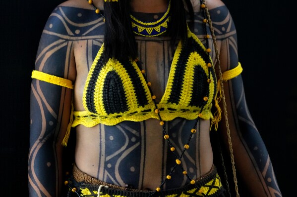 An Indigenous woman wearing traditional body paint and handcrafted clothing poses for a portrait during the opening of the "Acampamento Terra Livre," or Free Land Encampment, Brazil's largest annual Indigenous mobilization that focuses on land rights and environmental protection, in Brasilia, Brazil, Monday, April 6, 2026. (AP Photo/Eraldo Peres)