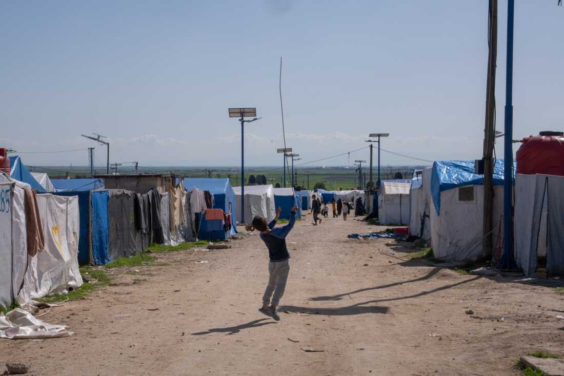 Children play between the rows of tents at Roj. 