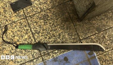 A black machete lies on the train platform.