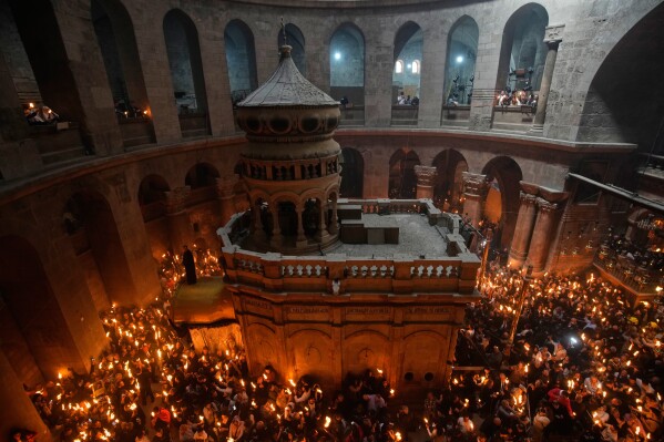 Christian Orthodox pilgrims hold up candles during the Holy Fire ceremony, at the Church of the Holy Sepulcher, the site where, according to tradition, Jesus was crucified and buried, in the Old City of Jerusalem, Saturday, April 11, 2026. (AP Photo/Ohad Zwigenberg)
