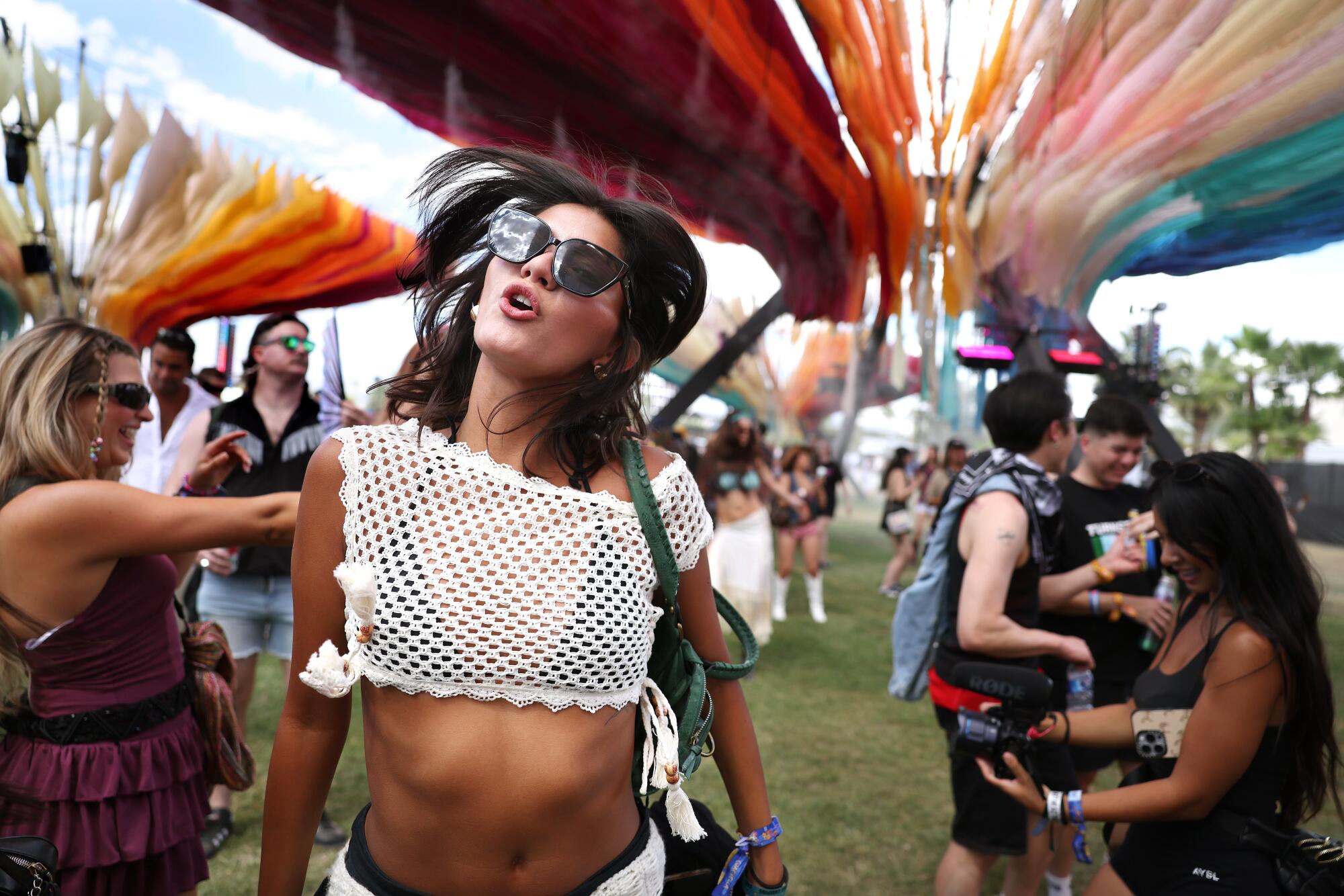 Ava Acuesta dances under a multicolored art installation.