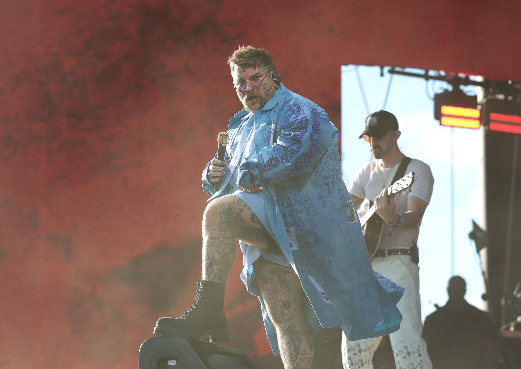Teddy Swims performs on the Coachella stage in a long blue jacket.