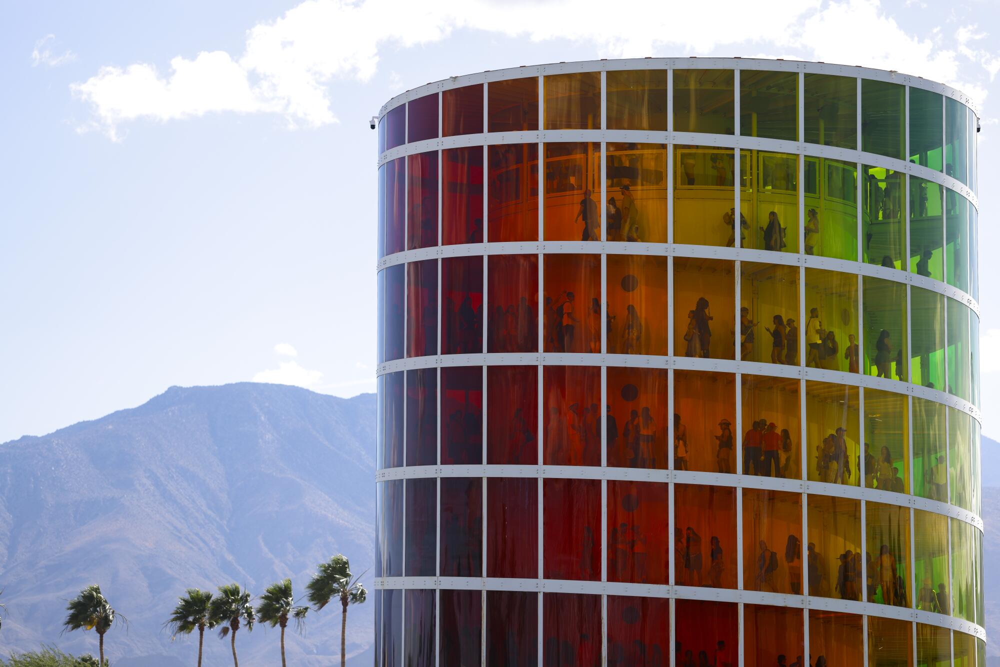 Festival goers climb up the multicolored, multi-tiered SPECTRA structure.