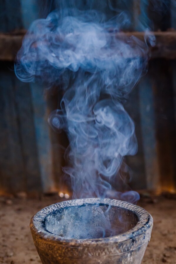 Myrrh burns in a traditional clay vessel in a home to ward off bugs, snakes and to fumigate it Friday, Jan. 9, 2026, in Sanqotor, Ethiopia. (AP Photo/Julianne Gauron)