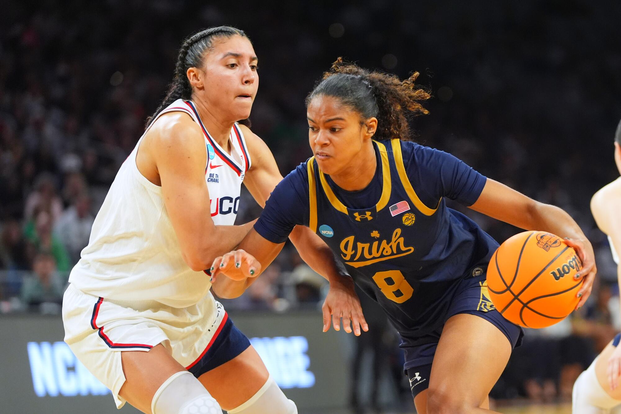 Notre Dame guard Cassandre Prosper drives to the basket under pressure from UConn guard Azzi Fudd.
