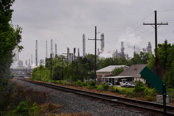 The Norco oil refinery is seen behind train tracks and residences in Norco, La., on April 2, 2026. (AP Photo/Gerald Herbert, File)