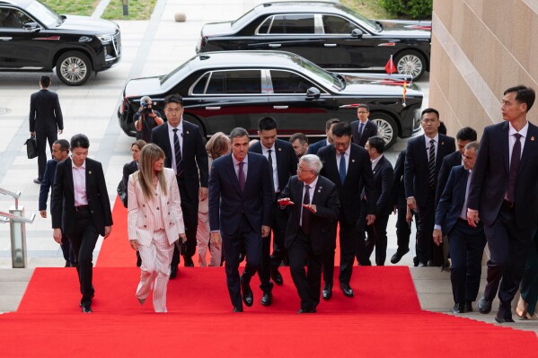 Spanish Prime Minister Pedro Sanchez, center left, and his wife Begona Gomez arrive at the University of Chinese Academy of Sciences in Beijing, Monday, April 13, 2026. (Andres Martinez Casares/Pool Photo via AP)