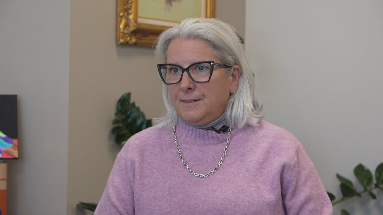 woman with long silver hair in pink sweater 