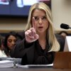 Seated behind a microphone, Attorney General Pam Bondi raises her index finger in the air while testifying before the House Judiciary Committee.
