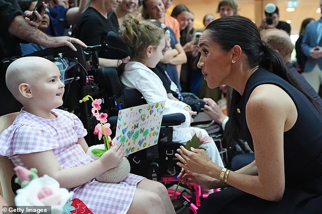 MELBOURNE, AUSTRALIA - APRIL 14: Meghan, Duchess of Sussex receives flowers and a card from a young patient on a visit to the Royal Children's Hospital with her husband Prince Harry, Duke of Sussex on April 14, 2026 in Melbourne, Australia. The royal couple are on a four-day visit to Australia, with engagements across Melbourne, Canberra and Sydney. (Photo by Jonathan Brady-Pool/Getty Images)