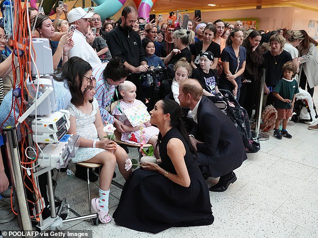 Britain's Prince Harry (C), Duke of Sussex, and his wife Meghan (L), the Duchess of Sussex, meet patients and their families during a visit at the Royal Children's Hospital in Melbourne on April 14, 2026. (Photo by Jonathan Brady / POOL / AFP via Getty Images) 15734007