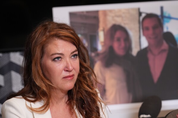 Lonna Drewes reacts during a news conference in Beverly Hills, Calif., Tuesday, April 14, 2026, to detail allegations of sexual misconduct by Rep. Eric Swalwell, after Swalwell exited the California governor's race and said he'll resign his seat in Congress. The AP typically does not identify people who say they are victims of sexual assault unless they identify themselves publicly. (AP Photo/Damian Dovarganes)