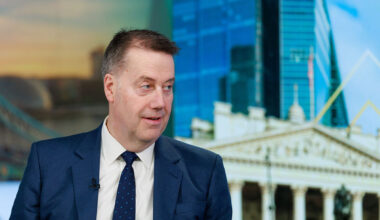 Andy Briggs, Chief Executive of Standard Life, addressing a business conference, wearing a suit and speaking at a podium.