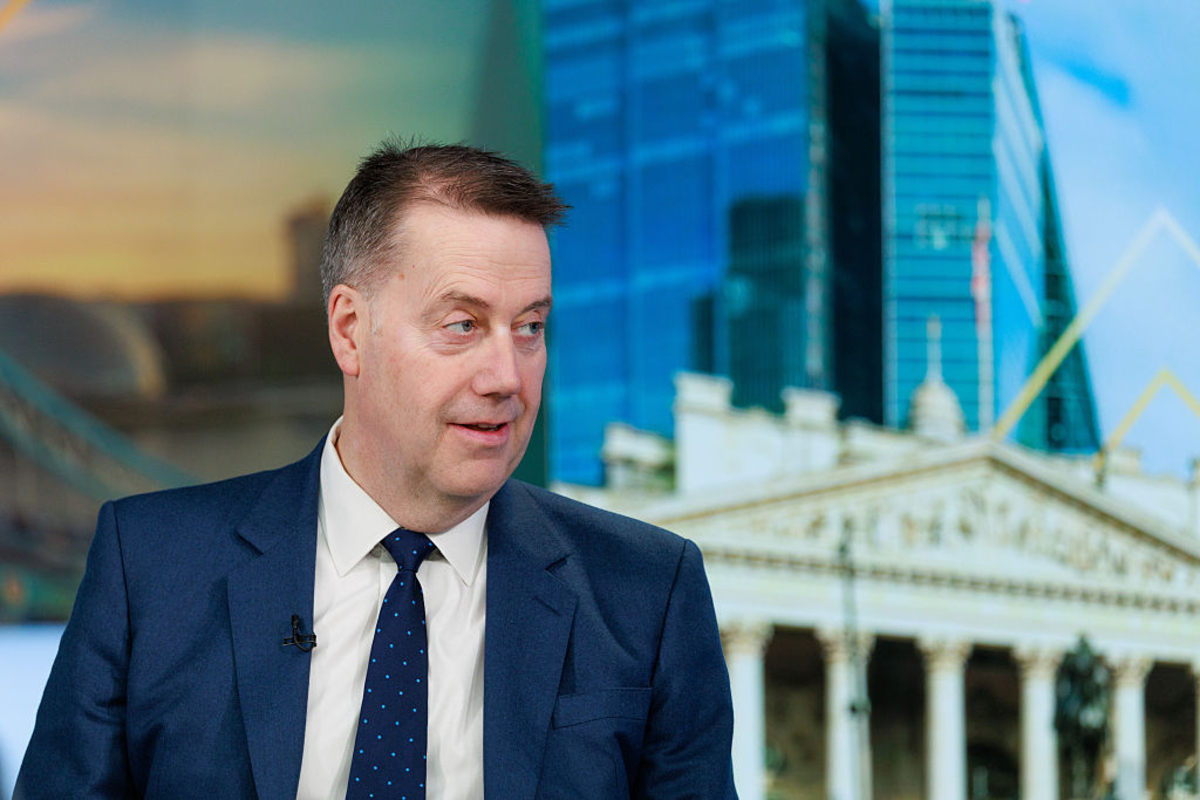 Andy Briggs, Chief Executive of Standard Life, addressing a business conference, wearing a suit and speaking at a podium.