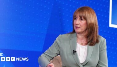 Head and shoulders of Rachel Reeve in a pale grey-green suit with clip microphone during the interview.