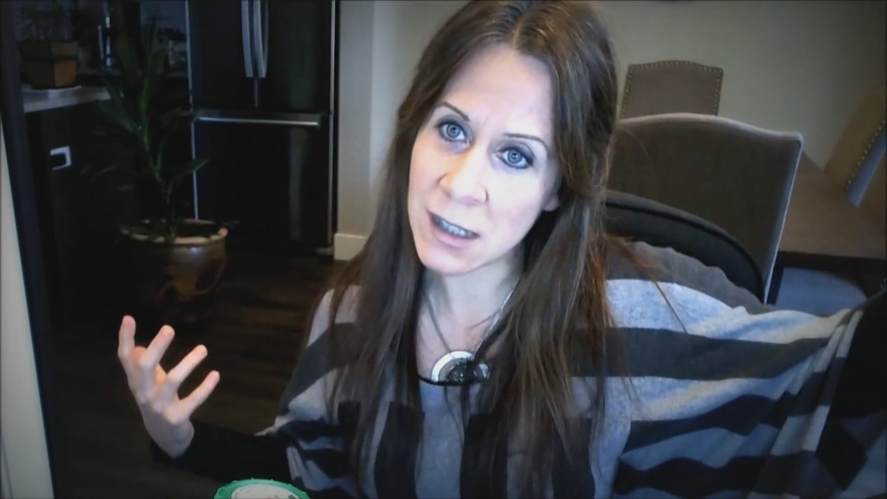 A screenshot of a woman sitting in a chair.