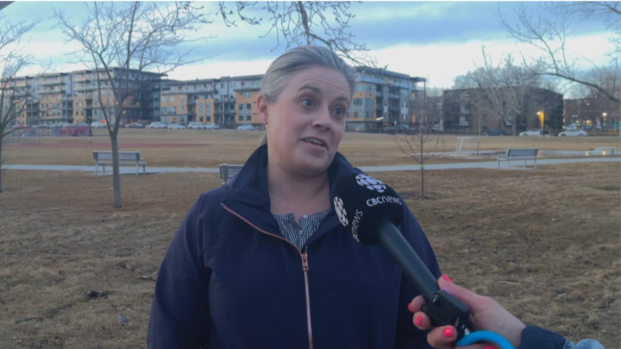 woman in blue zipup coat talking to a microphone